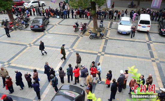 圖為10月28日，在江西九江市一家羊絨皮草服裝服飾博覽會現(xiàn)場，老人們正在頂著寒風(fēng)排隊等待領(lǐng)取10元代金劵。