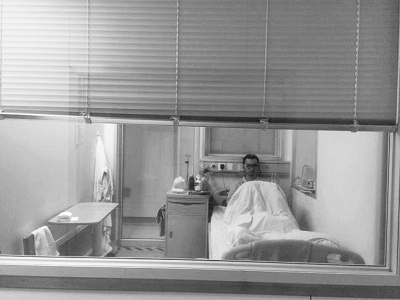 楊杰在醫(yī)院隔離病房中，沖記者揮了揮手。