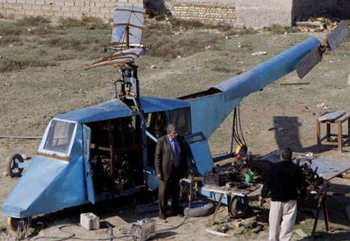 哈蒂姆·卡迪姆·薩爾曼正與工人交談，背后就是他正在制造的直升機(jī)