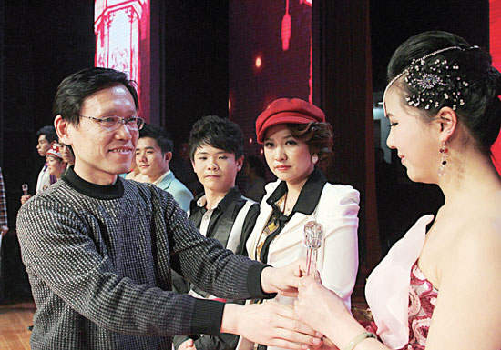 2013年2月1日，《對9當(dāng)歌》總決賽在鄭州開唱。圖為東方今報(bào)副社長胡楊為選手頒獎(jiǎng)