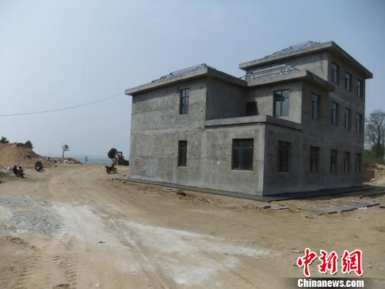 鴨河水庫(kù)庫(kù)區(qū)邊的新建別墅，一面墻上寫(xiě)著“拆”，另一邊在加緊施工。吳揚(yáng)　攝